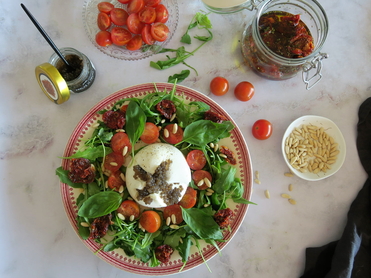 Ensalada de burrata con piñones y perlas de trufa negra